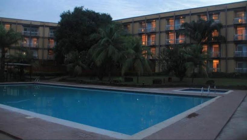 a swimming pool in front of a large building at Ryan hotel Abakaliki in Enugu