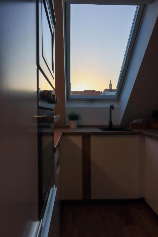 a kitchen with a large window and a sink at Apartmány Mikulovské zahrady in Mikulov