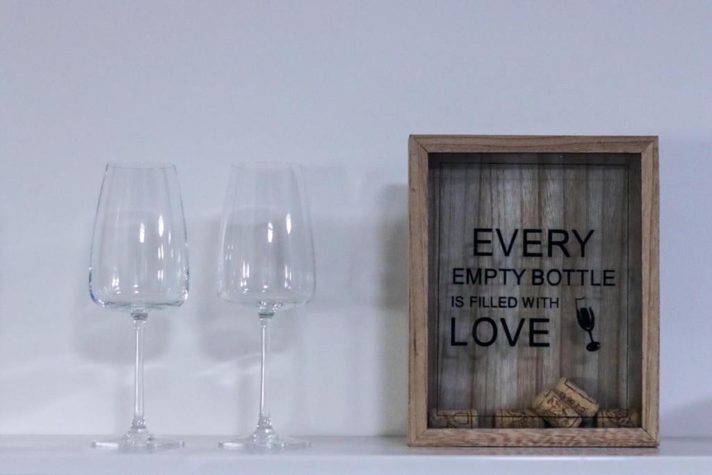 two wine glasses and a picture in a wooden frame at Apartmány Mikulovské zahrady in Mikulov