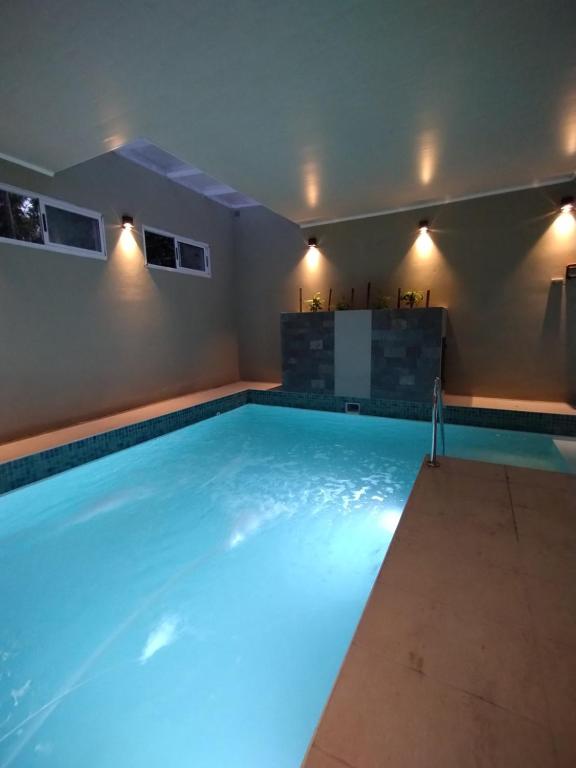 una piscina con iluminación azul en una casa en Cabañas El Refugio en Chascomús