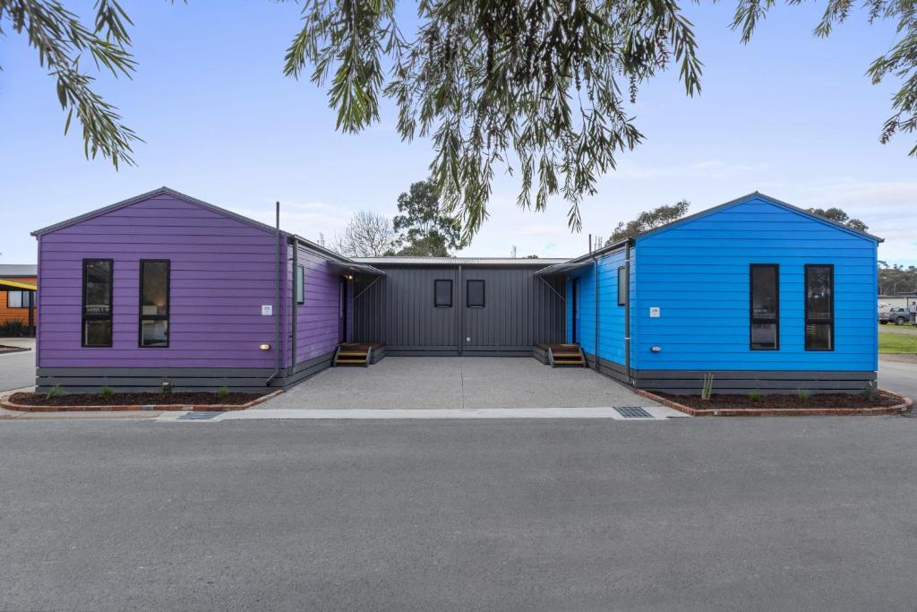 two purple and blue buildings in a parking lot at BIG4 Bendigo Park Lane Holiday Park in Bendigo
