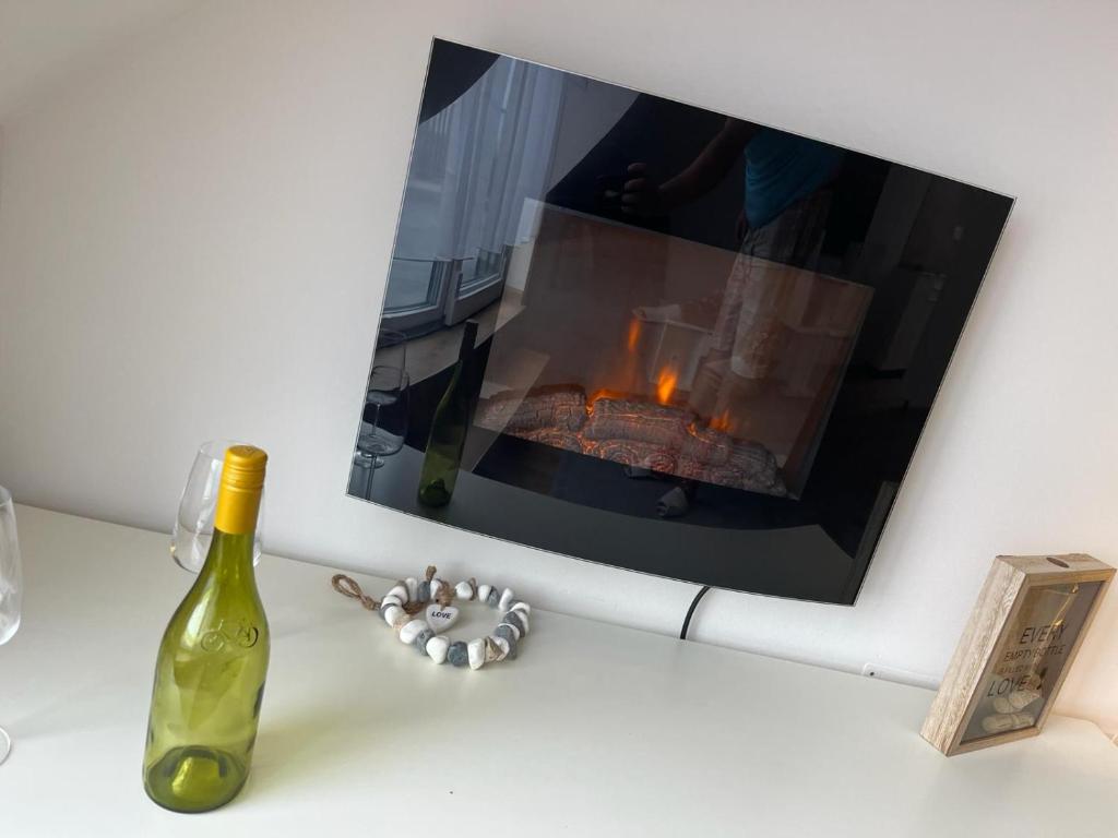 a bottle of wine next to a fireplace at Apartmány Mikulovské zahrady in Mikulov