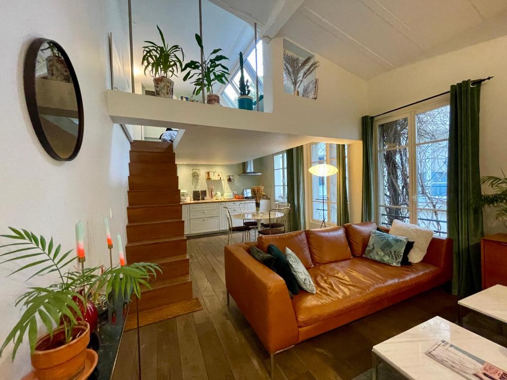 un salon avec un canapé et une cuisine dans l'établissement Maison Marais - calme et terrasse, à Paris