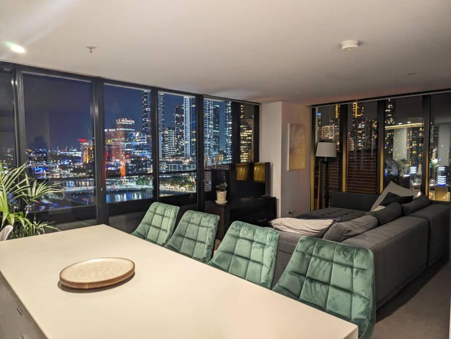 een woonkamer met een bank en een tafel bij Breathtaking views of Yarra River and City skyline with Free parking Gym access in Melbourne