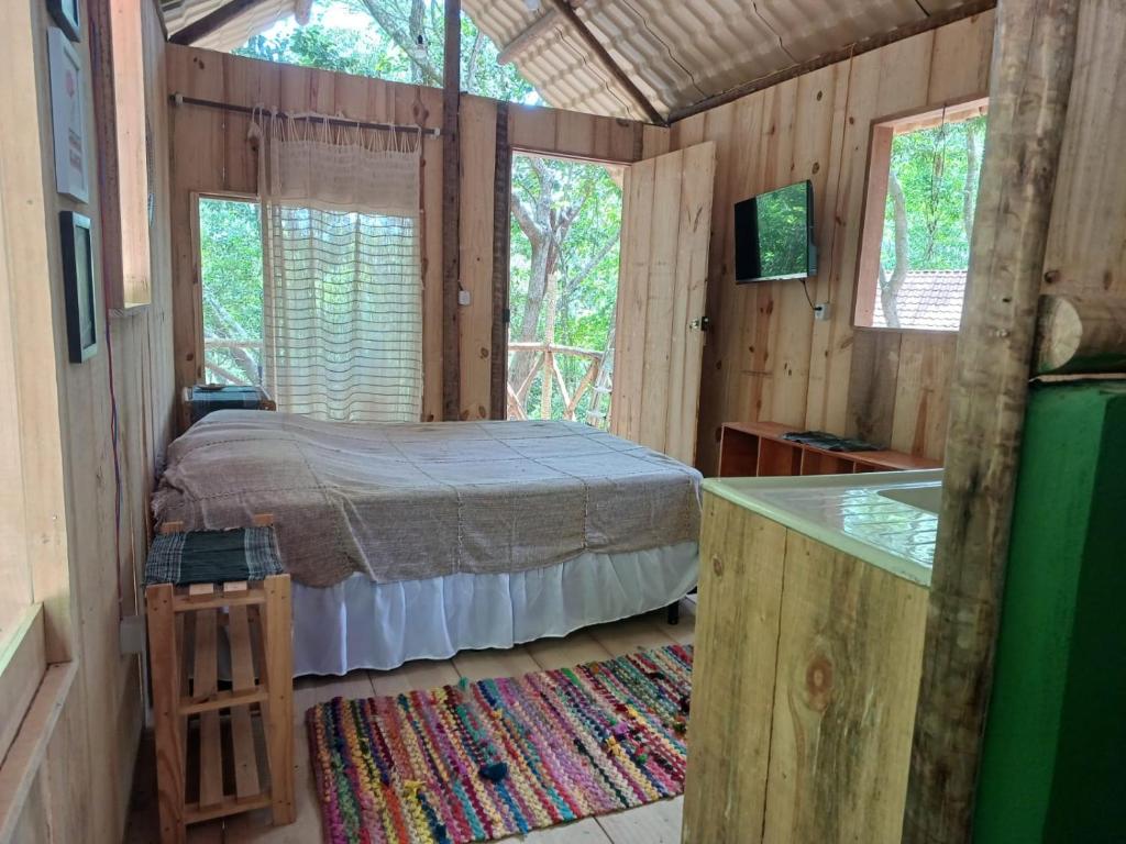 ein Schlafzimmer in einem Blockhaus mit einem Bett darin in der Unterkunft RECANTO DO SENTIR, conexão com a natureza e muita paz. in Praia do Forte