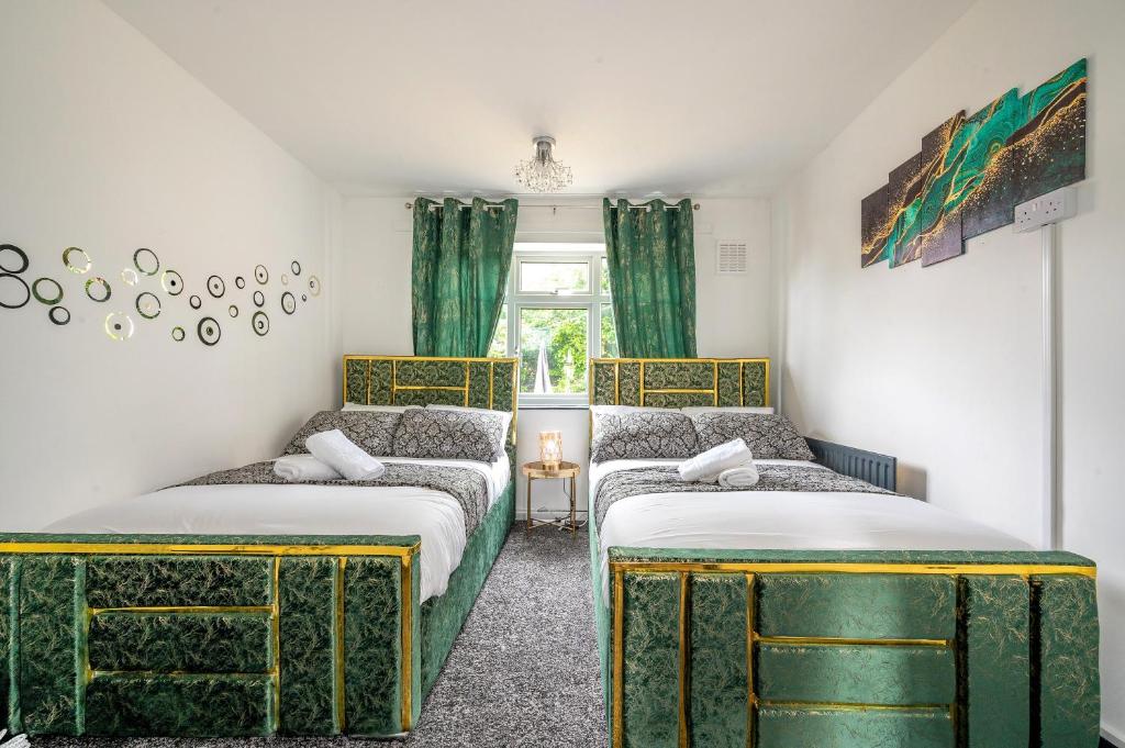two beds in a room with green and golditures at *RA26S* For your most relaxed & Cosy stay + Free Parking + Free Fast WiFi * in Adel