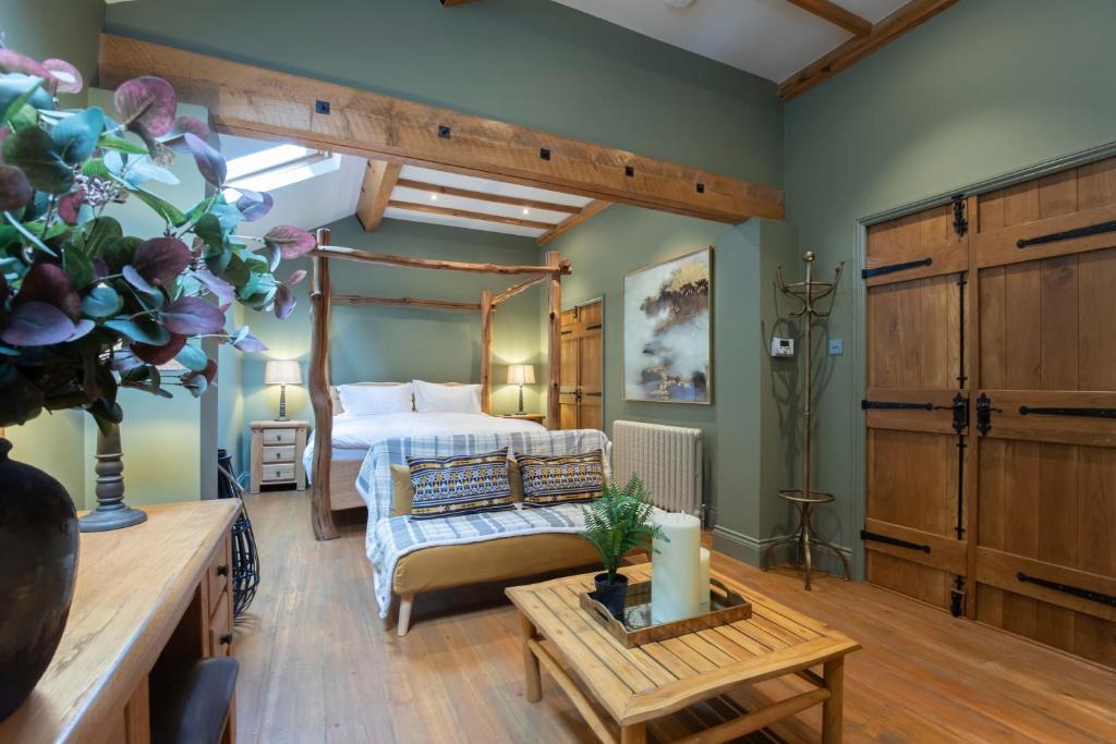 una grande camera da letto con un letto e un tavolo di Stable Lodge - Boutique Bed & Breakfast a Cheltenham