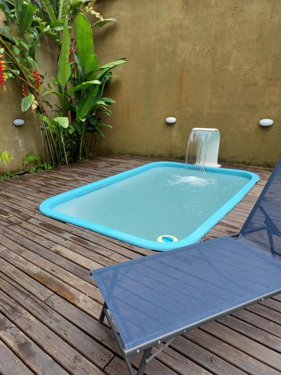 une piscine bleue avec une chaise sur une terrasse dans l'établissement Loft em Caldas da Imperatriz - SC, à Santo Amaro da Imperatriz