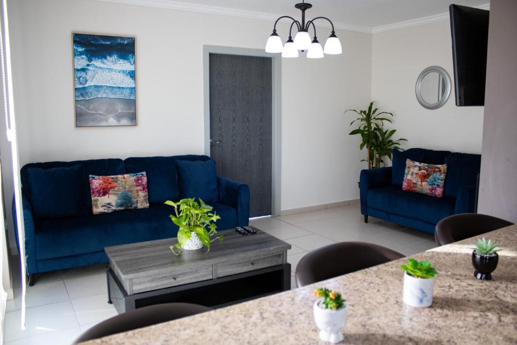 a living room with blue couches and a table at Great family apartment in Tegucigalpa in Tegucigalpa