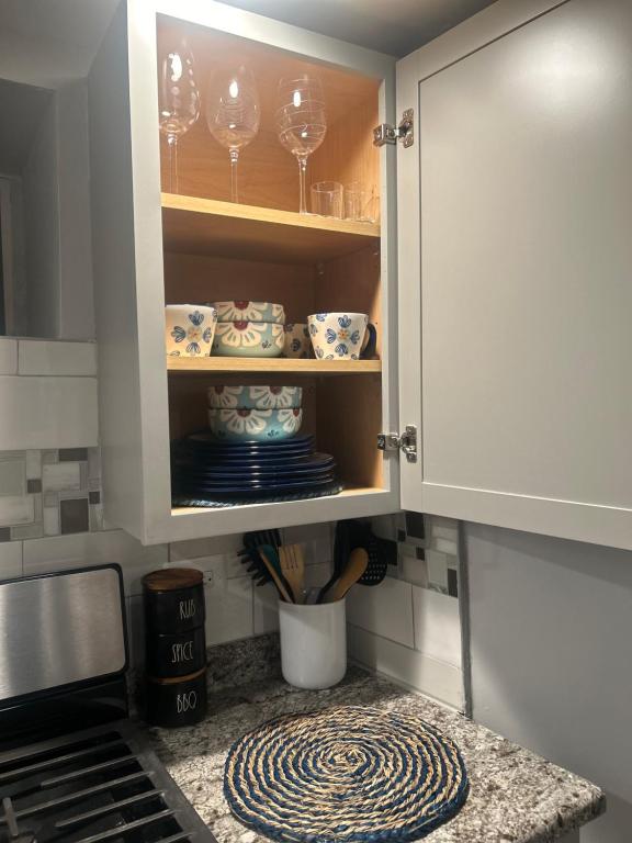 een keukenkast met borden en wijnglazen erin bij Sunny Girasol Garden in Broadview