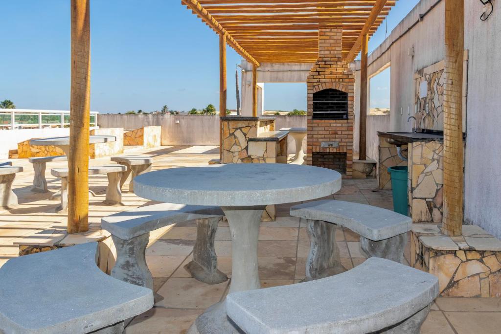 a picnic table and benches on a patio at Aloha Vibes Ap Cumbuco - Green Club in Cumbuco
