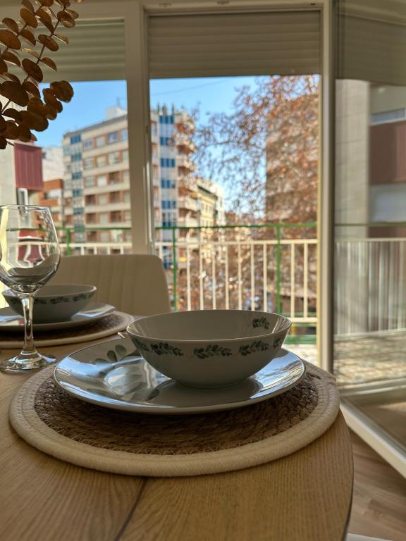 a table with bowls and plates on a table with a window at El Molino in Albacete