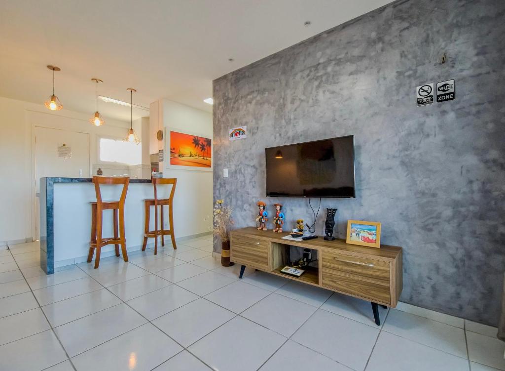 a living room with a flat screen tv on a wall at Aloha Vibes Ap Cumbuco - Green Club in Cumbuco