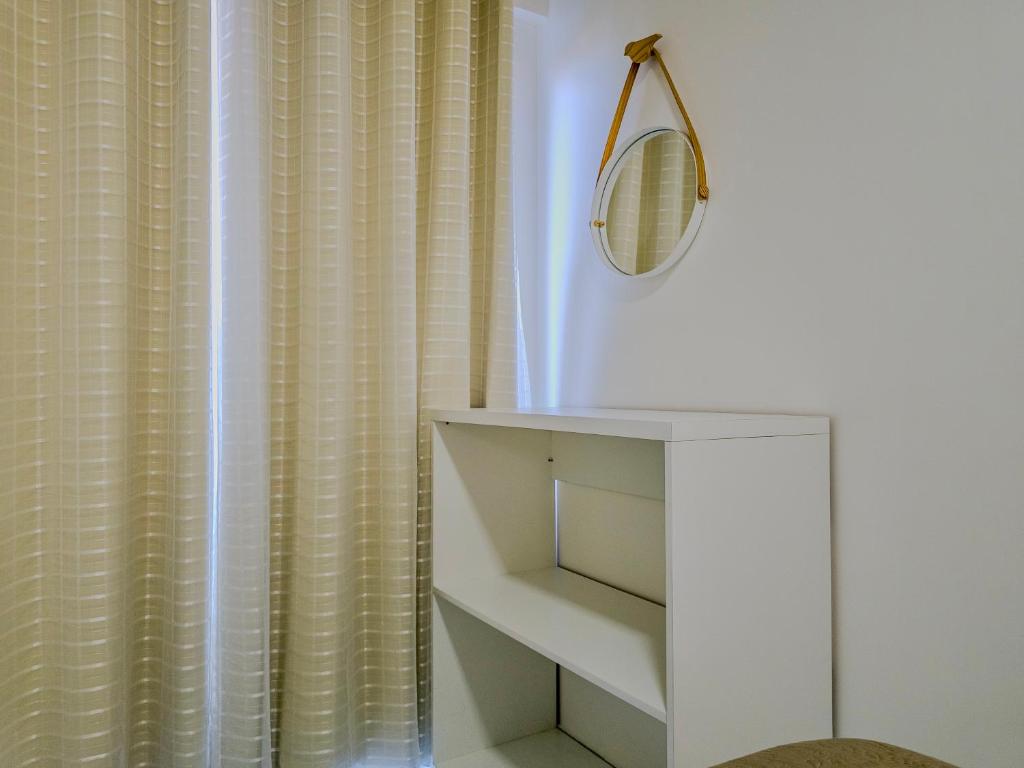 a bathroom with a white shower curtain and a mirror at Aloha Vibes Ap Cumbuco - Green Club in Cumbuco