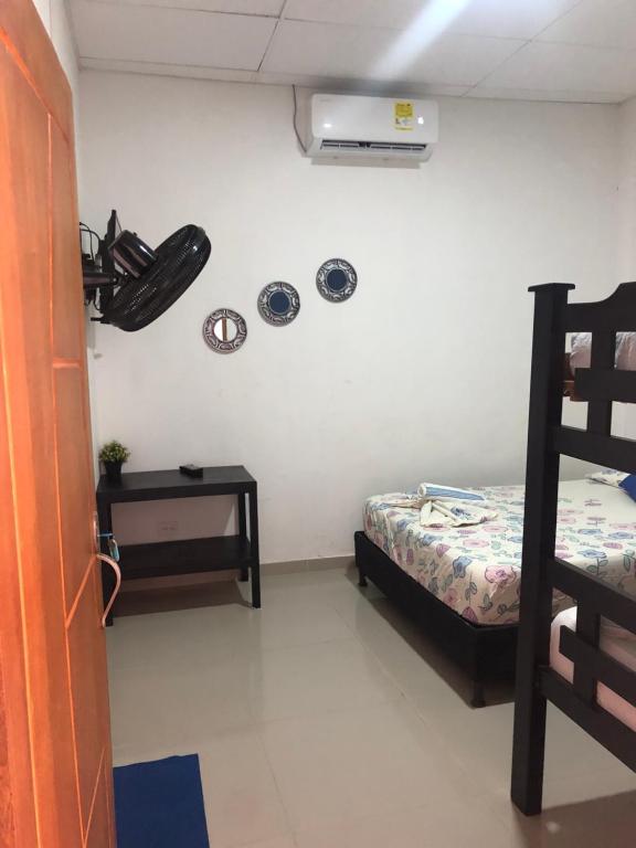 ein Schlafzimmer mit einem Bett und einem Nachttisch sowie einem Bett und einem m2 in der Unterkunft Mónaco habitaciones in Coveñas