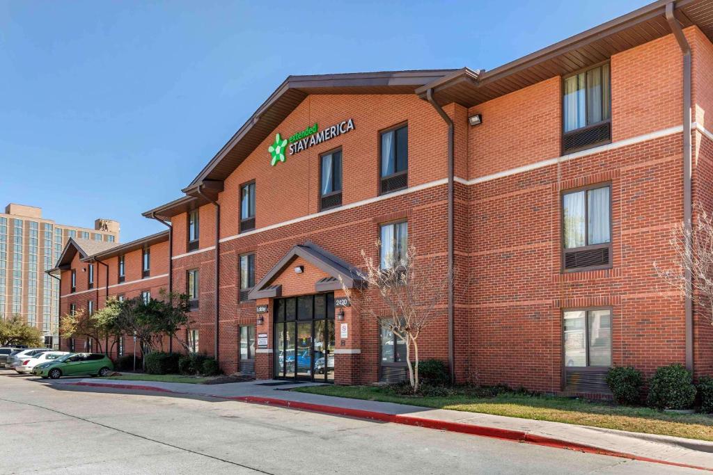 a red brick building with a star hotel at Extended Stay America Suites - Arlington - Six Flags in Arlington
