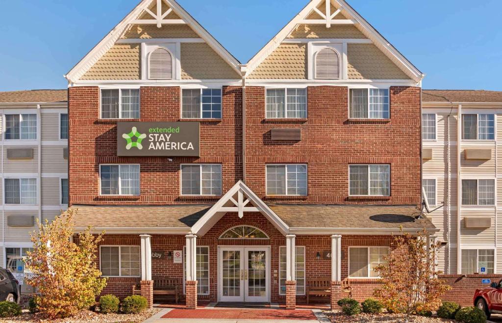 a large brick building with a sign on it at Extended Stay America Suites - Cincinnati - Blue Ash - Reed Hartman in Blue Ash