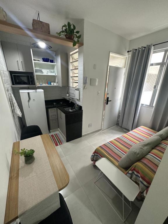 cocina y comedor con mesa y nevera en Acolhedor apartamento na quadra da praia, en Río de Janeiro