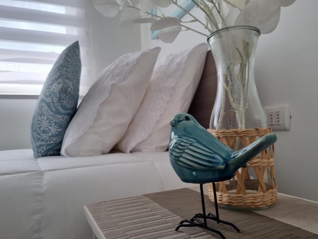 un pájaro azul sentado en una mesa junto a un sofá en Hostal Chucaita Puerto Cisnes en Puerto Cisnes
