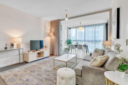 ein Wohnzimmer mit einer Couch, einem Fernseher und einem Tisch in der Unterkunft Charlotte Towers Brisbane & Resort Style Facilities in Brisbane