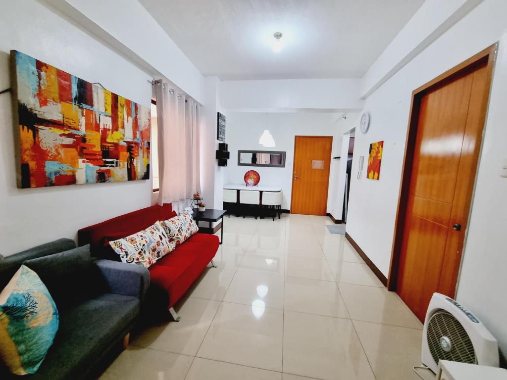 ein Wohnzimmer mit einer roten Couch in einem Zimmer in der Unterkunft Newport's STAR in Manila