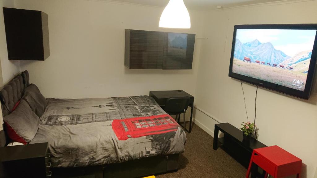 a bedroom with a bed and a flat screen tv at 3- Room in central London in London