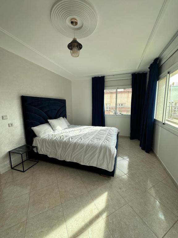 a bedroom with a large bed with a blue headboard at Appart matar in Nador