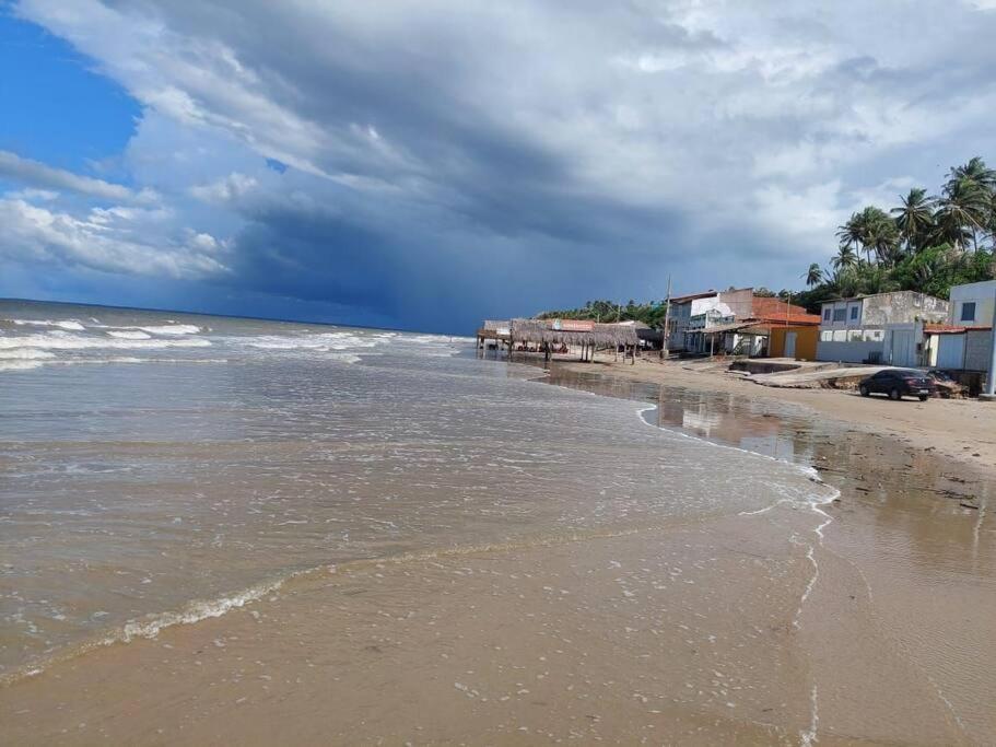 uma praia com o oceano e casas nele em Casa na Praia com Super Piscina, em Condomínio Fechado. em São José de Ribamar