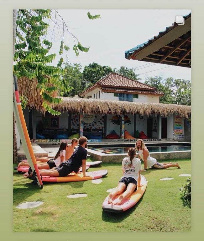 un gruppo di persone sedute su zattere nell'erba di Waiwas Hostel a Kuta Lombok