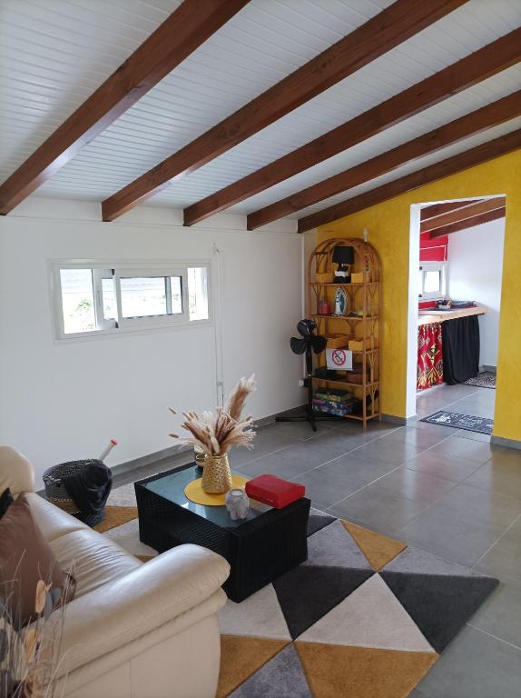 ein Wohnzimmer mit einem Sofa und einem Tisch in der Unterkunft Haut de villa dans le nord de la grande terre (Guadeloupe). in Anse-Bertrand