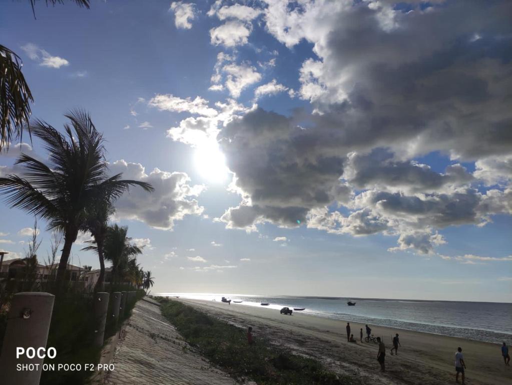 una spiaggia con una palma e il sole di Casa Luz / Beira Mar a Tutóia