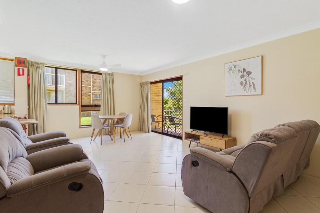 a living room with two couches and a flat screen tv at Unit 2 8 Banks Avenue in Tweed Heads