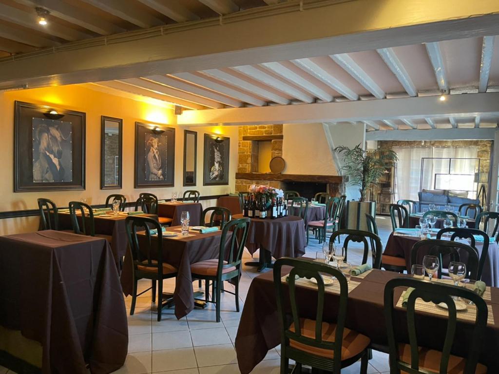a restaurant with tables and chairs in a room at Douce Demeure in Mortemart