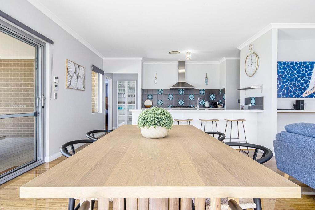 a dining room and living room with a wooden table at Killarney Retreat - Dunsborough in Dunsborough