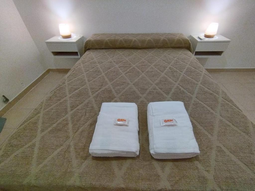 a bed with two white pillows on top of it at Andrade in Colón