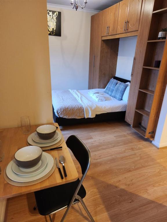 um pequeno quarto com uma mesa e uma cama em UK CHAPS Retreat: Private Chelsea Studio em Londres