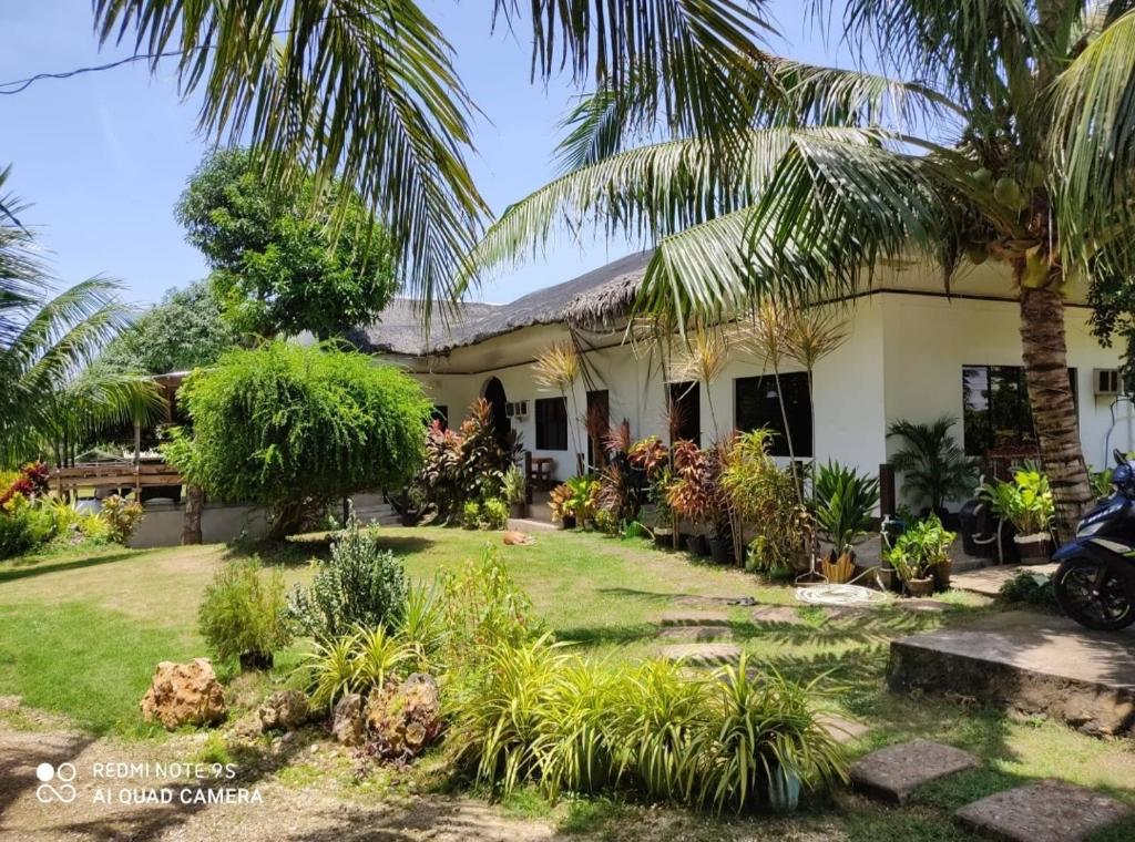 una casa con palmeras delante en Apoestin homestay en Siquijor