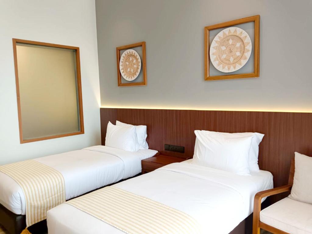 a hotel room with two beds and a mirror at INDO ALAM RECREATIONAL RESORT in Sindanglaya