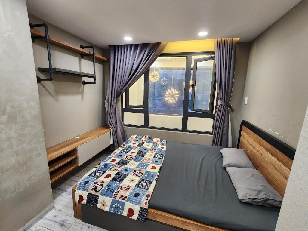 um pequeno quarto com uma cama e uma janela em Cozy house near Pink Church em Cidade de Ho Chi Minh