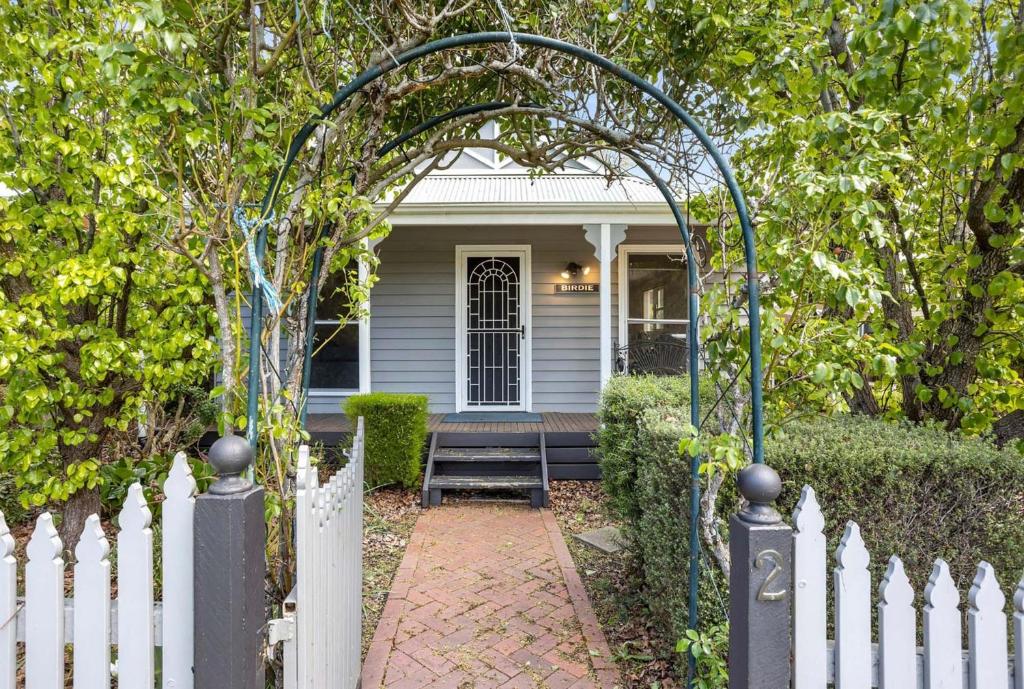 a white fence with a gate in front of a house at Birdie Daylesford in Daylesford