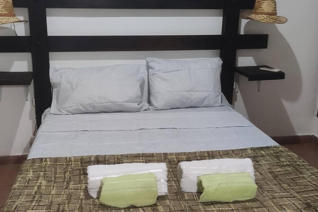 a bed with two pillows and two towels on it at Departamento para 4 personas. in Maipú