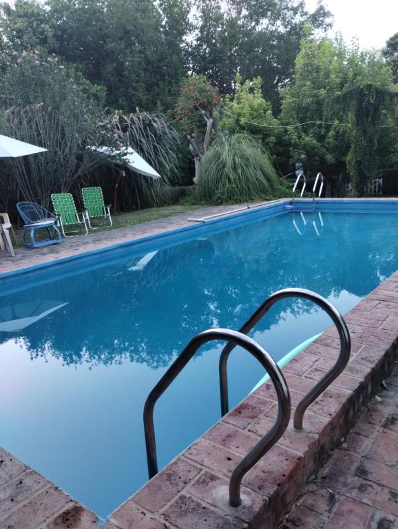 uma piscina com um corrimão de metal ao lado em Cabañas de madera 25 m2 Estilo Rústico em La Granja