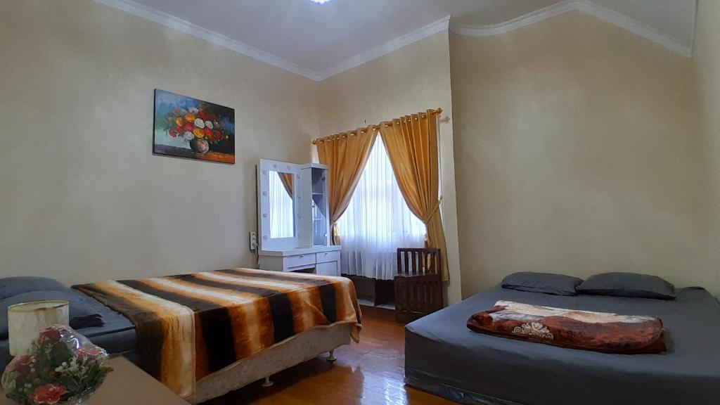 1 dormitorio con 2 camas y ventana en Vila Dinar Mountain View Lembang, en Lembang
