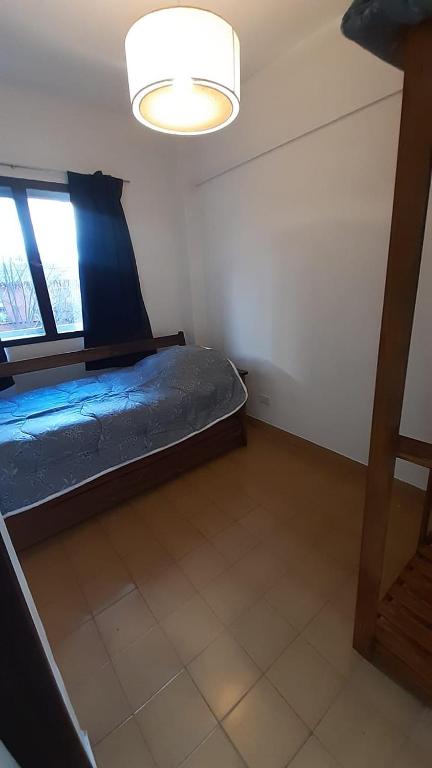 een slaapkamer met een blauw bed in een kamer bij Departamento de 2 habitación para 4 personas in Bariloche