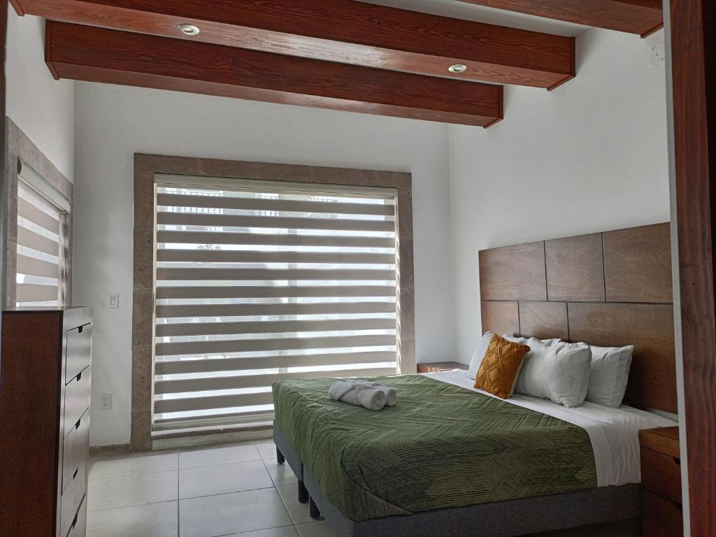 - une chambre avec un lit et une grande fenêtre dans l'établissement Los Arcos Hottel Boutique, à Morelia