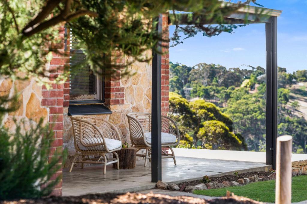 un patio con 2 sillas, una mesa y una ventana en Rossini's Cottage - Hills Escape, 