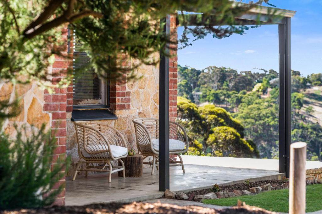 a patio with two chairs and a table and a window at Rossini's Cottage - Hills Escape in Mount Lofty