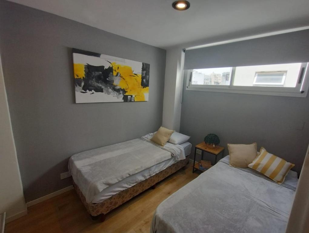 1 dormitorio con 2 camas y ventana en Dúplex en Flores para 4 personas en Buenos Aires