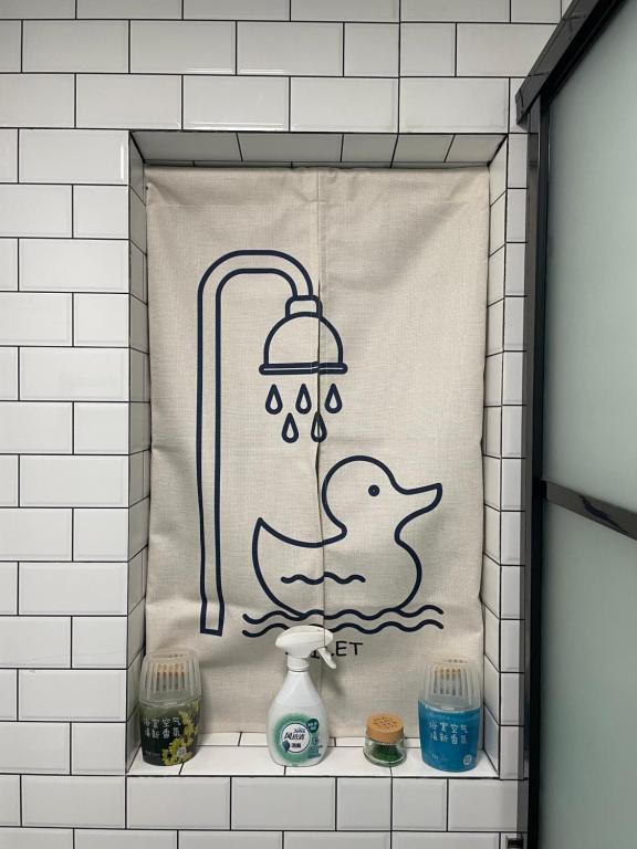 a shower curtain with a duck in the water at 1930 French Minimalist Apartment in Shanghai