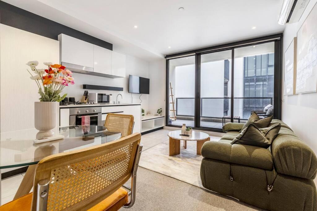 uma sala de estar com um sofá e uma mesa em Central & Stylish in St Kilda w AC, WiFi & Balcony em Melbourne